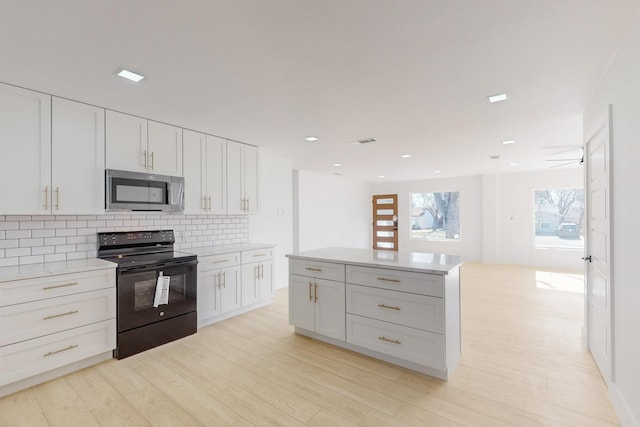 kitchen with backsplash, white cabinetry, black range with electric stovetop, and light hardwood / wood-style flooring