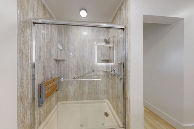 bathroom with hardwood / wood-style flooring and a shower with door