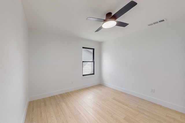 empty room with ceiling fan and light hardwood / wood-style flooring