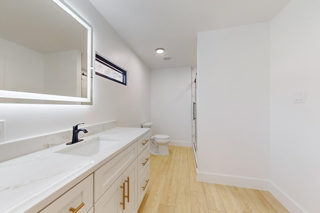 bathroom with hardwood / wood-style flooring, toilet, and vanity