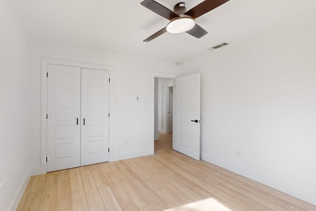 unfurnished bedroom featuring light hardwood / wood-style flooring, a closet, and ceiling fan