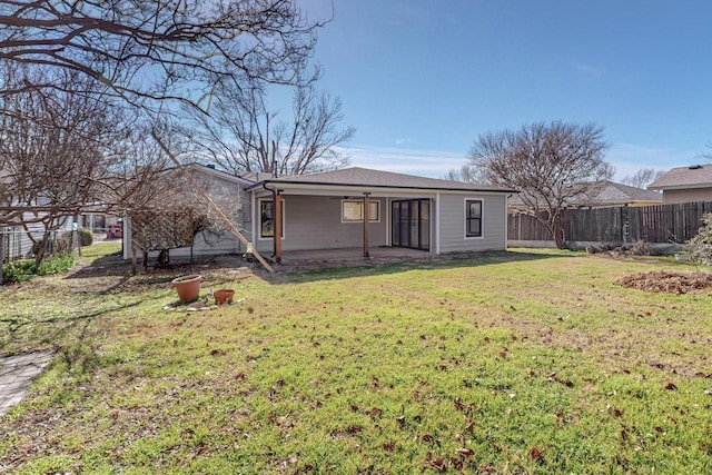 rear view of house featuring a lawn and a patio