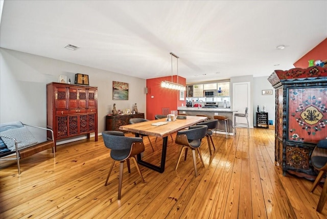 dining space with sink and light hardwood / wood-style flooring