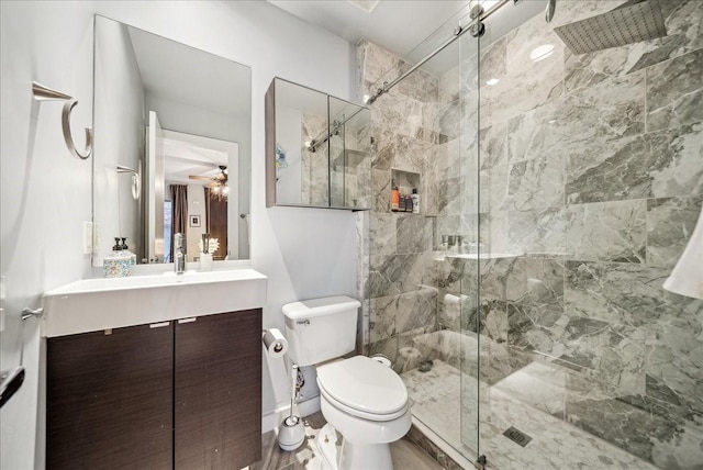 bathroom with vanity, toilet, ceiling fan, and a shower with shower door