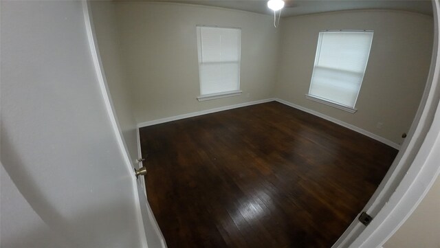1104 Prairie Ave, Cleburne, TX 76033 - spare room with a ceiling fan, baseboards, dark wood-style flooring, and plenty of natural light