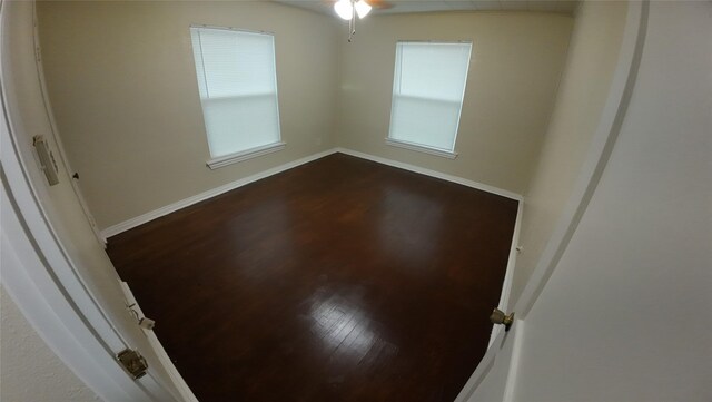 1104 Prairie Ave, Cleburne, TX 76033 - spare room with a ceiling fan, baseboards, dark wood-style flooring, and plenty of natural light