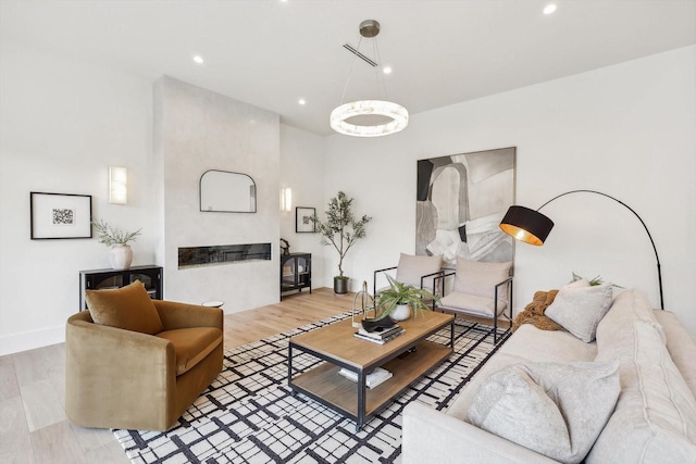 living room with a large fireplace and light wood-type flooring