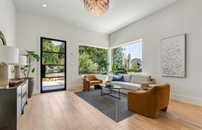 living room with light wood-type flooring and an inviting chandelier