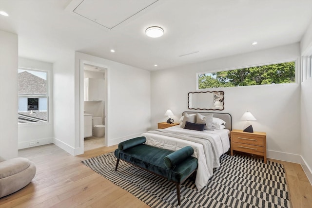 bedroom featuring ensuite bathroom and light hardwood / wood-style flooring