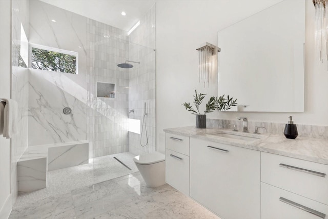 bathroom featuring vanity, a tile shower, and toilet