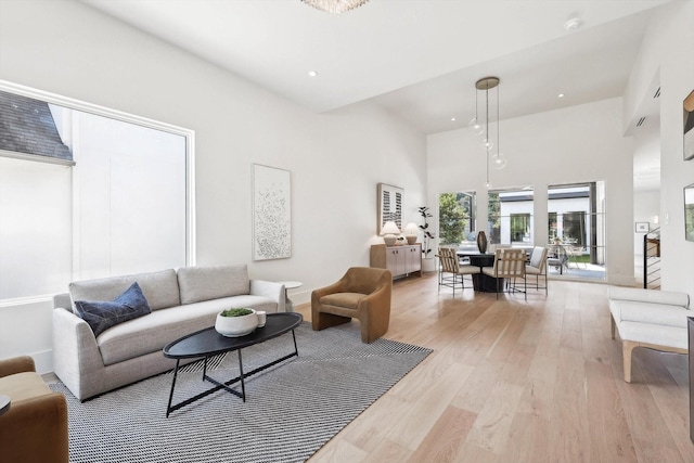 living room with a high ceiling and light hardwood / wood-style floors