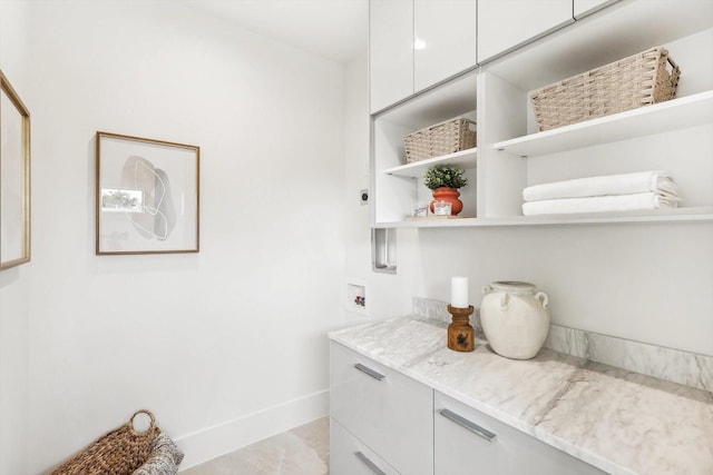 interior space featuring white cabinetry and light stone counters