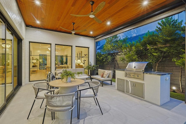 view of patio / terrace with ceiling fan, an outdoor kitchen, and grilling area