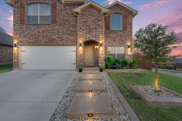 front facade with a garage and a yard