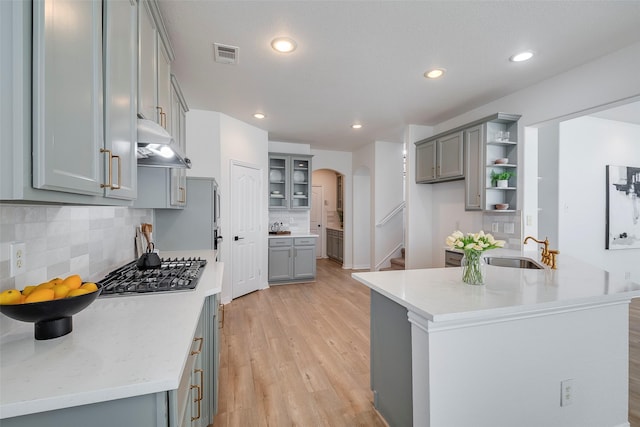 kitchen featuring sink, gray cabinetry, kitchen peninsula, and stainless steel gas cooktop