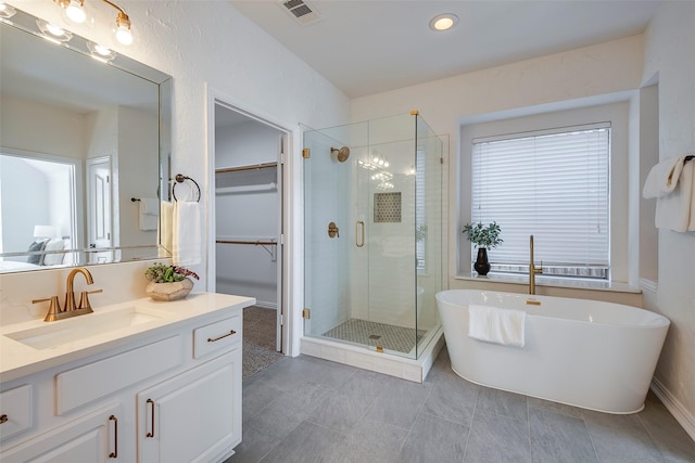 bathroom with tile patterned flooring, vanity, and plus walk in shower