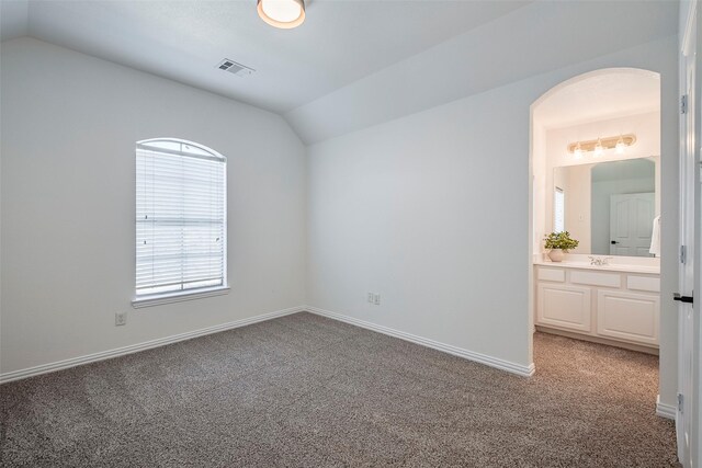 spare room with sink, carpet flooring, and lofted ceiling