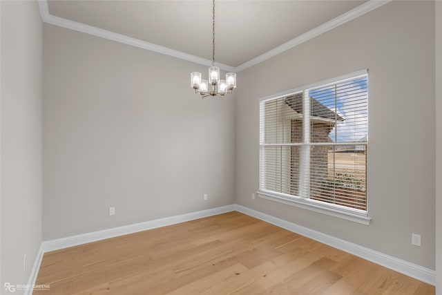 empty room with ornamental molding, hardwood / wood-style floors, and a notable chandelier