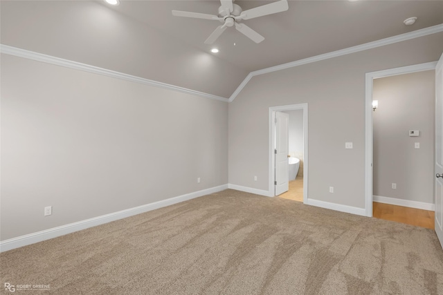 unfurnished bedroom featuring lofted ceiling, connected bathroom, crown molding, and light colored carpet