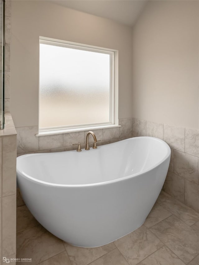 bathroom featuring tile walls and a bathtub