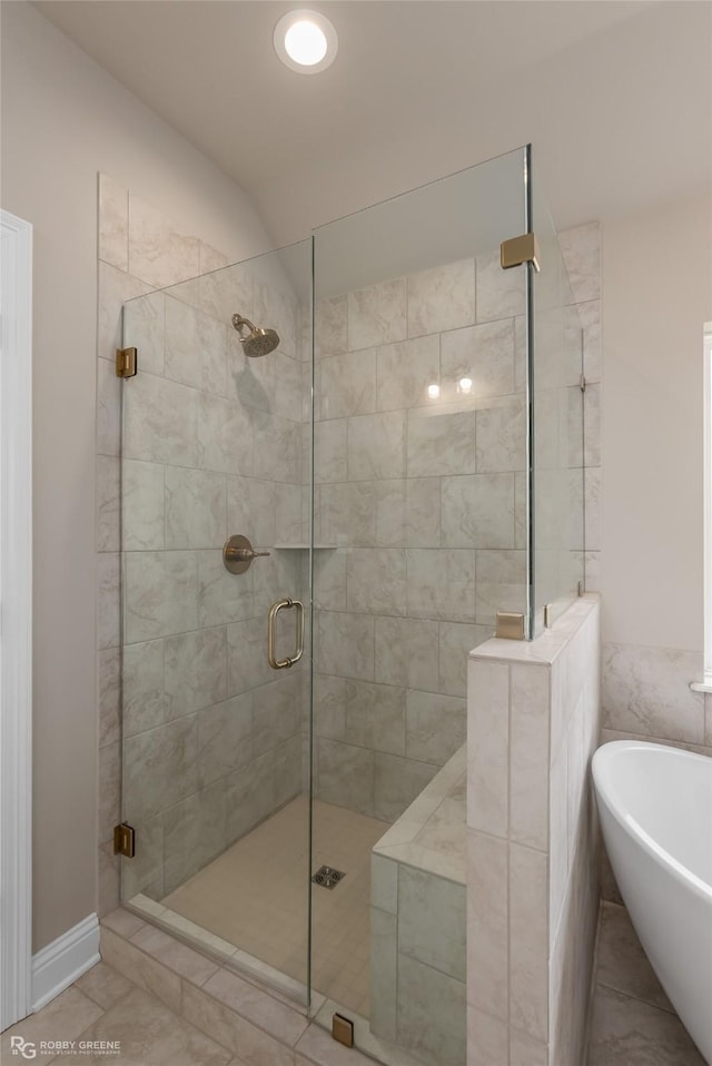 bathroom with separate shower and tub and tile patterned flooring