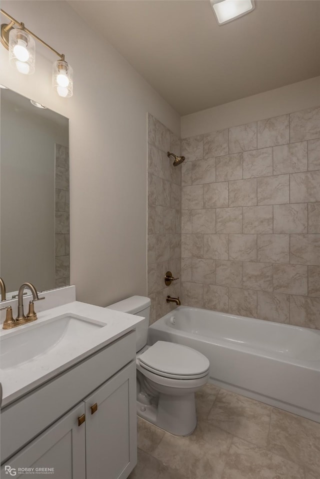 full bathroom with tiled shower / bath, vanity, and toilet