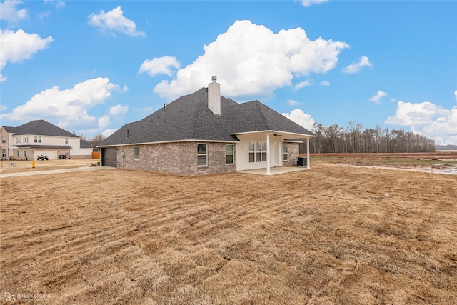 rear view of property featuring a yard and a patio area