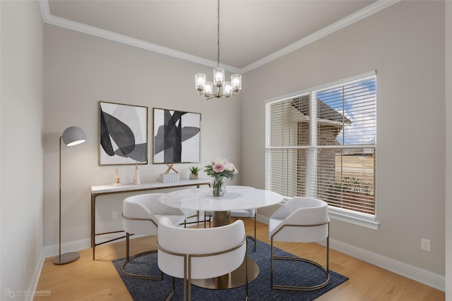 dining area featuring ornamental molding, plenty of natural light, light hardwood / wood-style flooring, and a notable chandelier