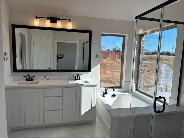 bathroom with a healthy amount of sunlight, vanity, and independent shower and bath