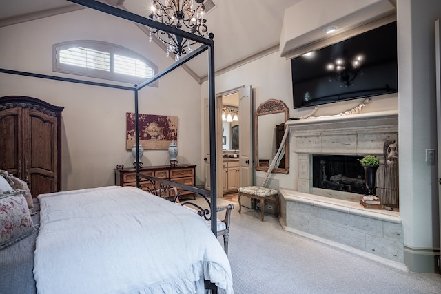 bedroom featuring lofted ceiling, ensuite bath, and carpet flooring