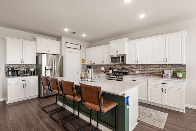 kitchen featuring a kitchen island with sink, sink, white cabinetry, and stainless steel appliances