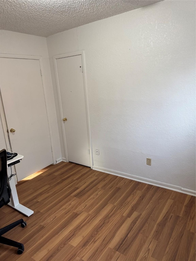 spare room with wood-type flooring and a textured ceiling