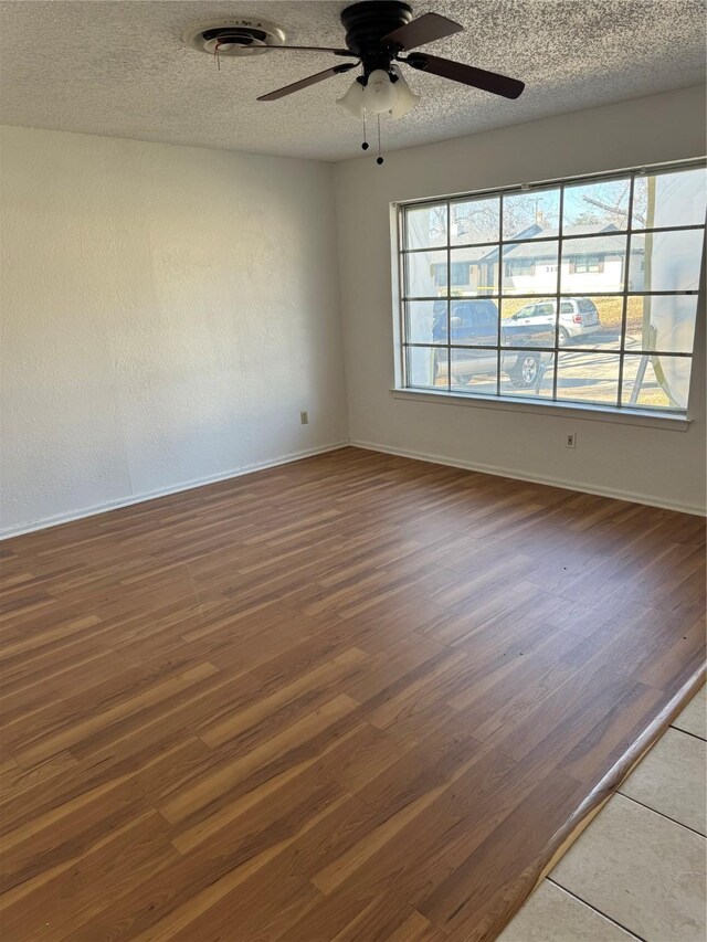 spare room with ceiling fan, dark hardwood / wood-style floors, and a textured ceiling