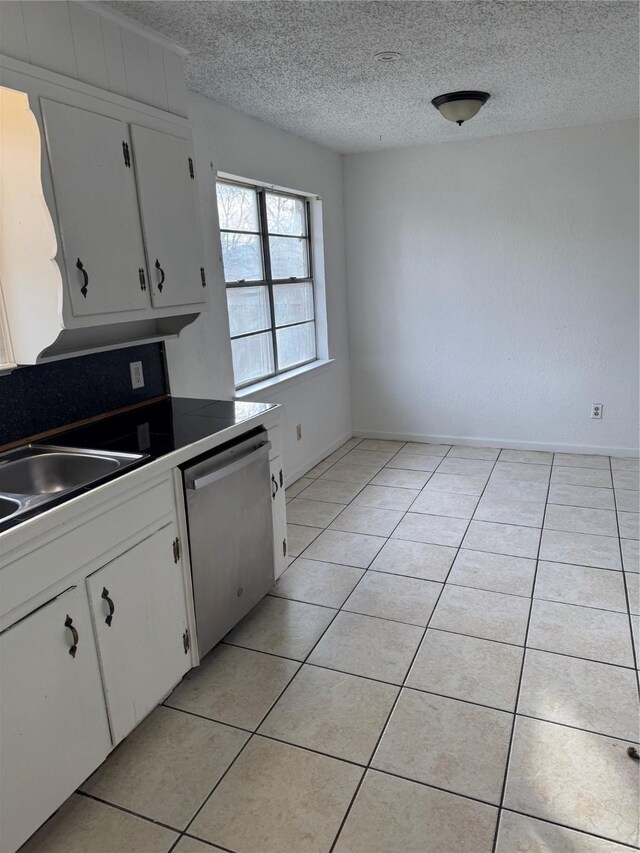 kitchen featuring white cabinetry, stainless steel dishwasher, and light tile patterned flooring