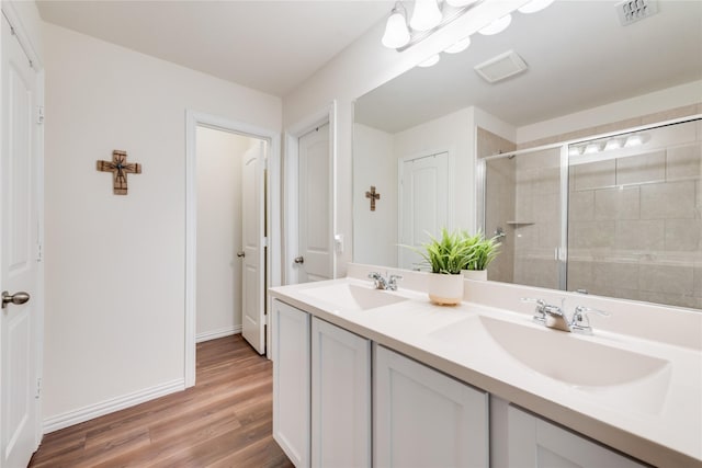 bathroom with wood-type flooring, an enclosed shower, and vanity