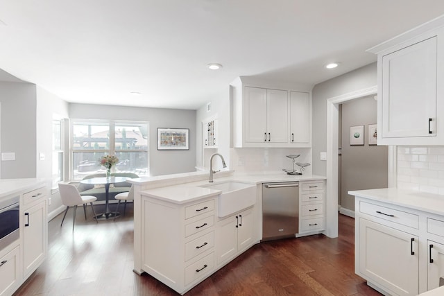 kitchen with sink, decorative backsplash, stainless steel dishwasher, and kitchen peninsula