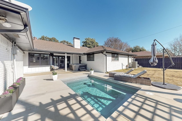 view of swimming pool with central AC unit, a lawn, a hot tub, and a patio