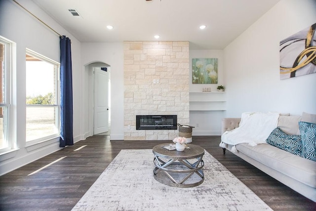 living room featuring dark wood-type flooring and a fireplace