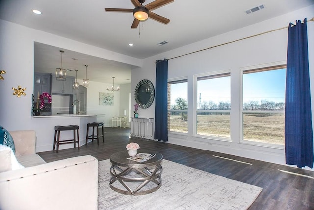 living room featuring sink, ceiling fan with notable chandelier, and dark hardwood / wood-style flooring