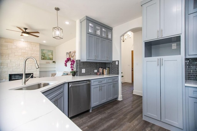 kitchen with sink, hanging light fixtures, backsplash, and dishwasher