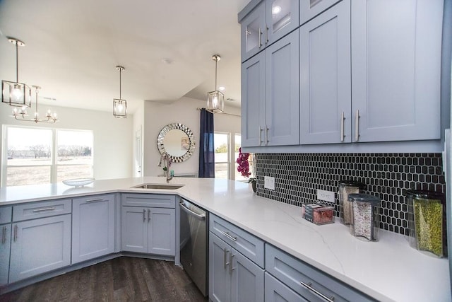 kitchen with pendant lighting, dishwasher, decorative backsplash, sink, and dark hardwood / wood-style floors