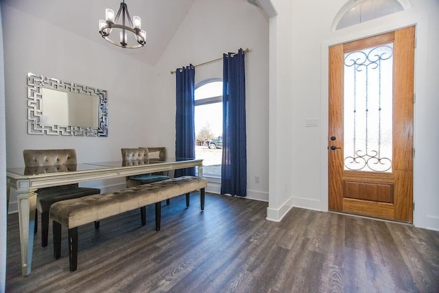 entryway featuring high vaulted ceiling, an inviting chandelier, and dark hardwood / wood-style flooring