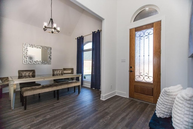 entryway with a notable chandelier, vaulted ceiling, and dark wood-type flooring