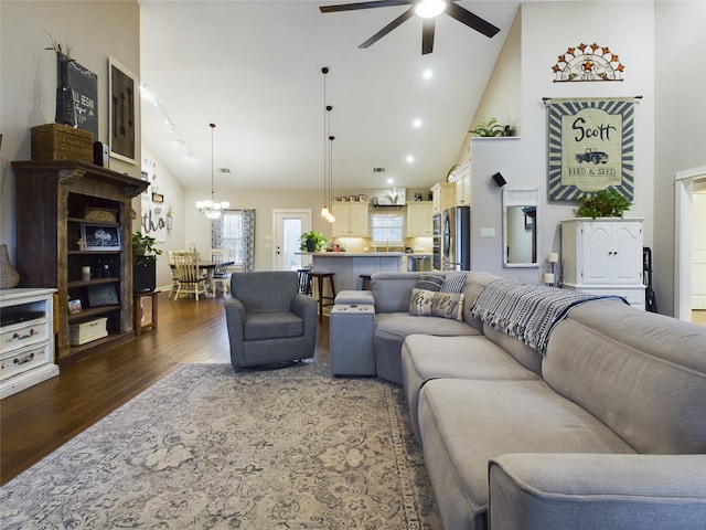 living room featuring ceiling fan with notable chandelier, high vaulted ceiling, and dark hardwood / wood-style flooring