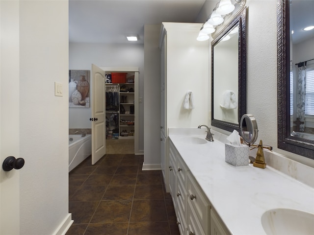 bathroom with a tub, tile patterned floors, and vanity