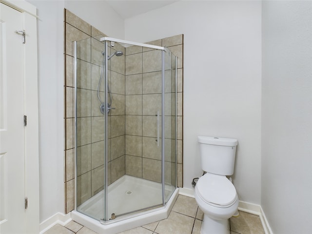 bathroom with toilet, tile patterned flooring, and a shower with shower door