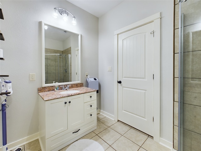 bathroom with a shower with door, tile patterned flooring, and vanity