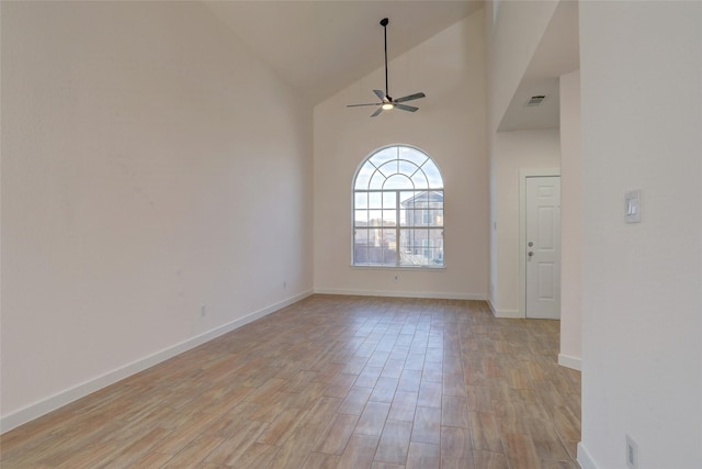 empty room with ceiling fan and high vaulted ceiling