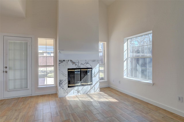 unfurnished living room featuring a high ceiling and a fireplace