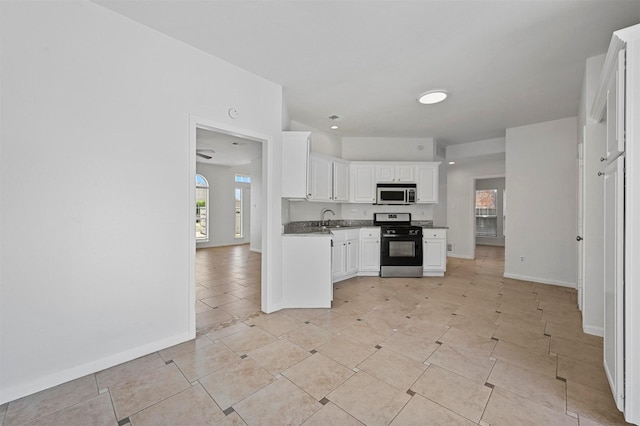 kitchen with sink, white cabinetry, light tile patterned floors, and appliances with stainless steel finishes